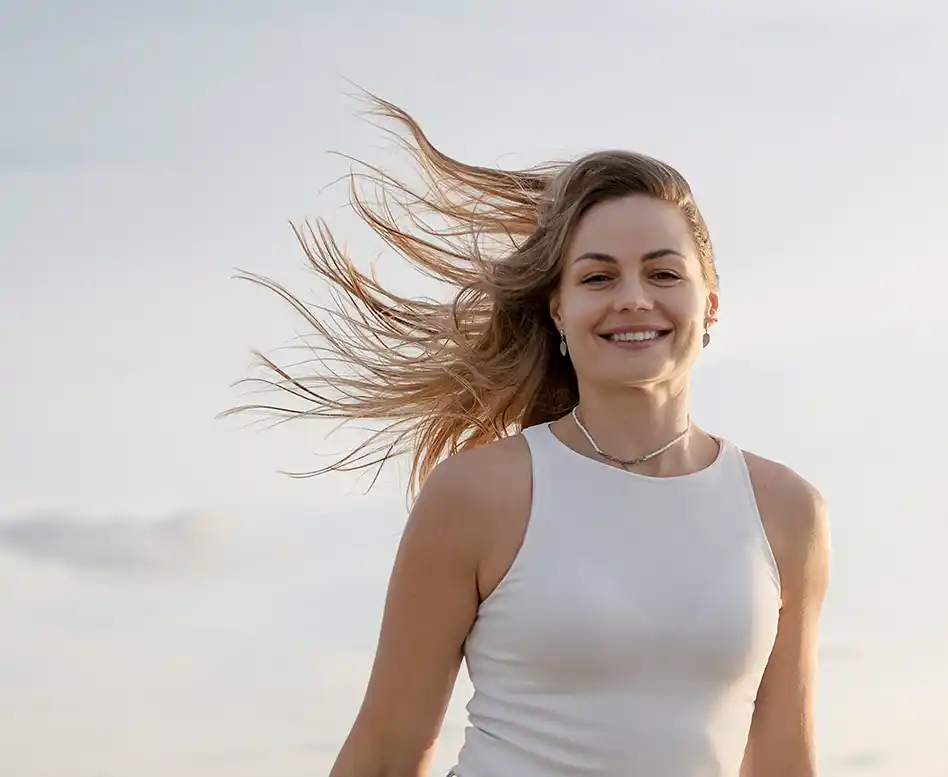 Glücklich aussehende Robbe am Strand, die Flosse wie beim Winken erhoben